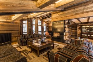 Luxurious wooden chalet with sofas at Chalet Ambre, La Mourra Hotel village.