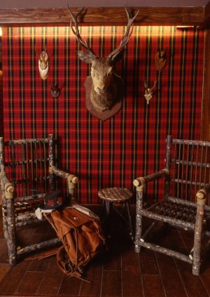 Antler head and wooden chairs in romantic French ski chalet, Le Lodge Park.
