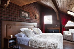 Cosy and romantic wooden ski chalet bedroom with soft furnishings.