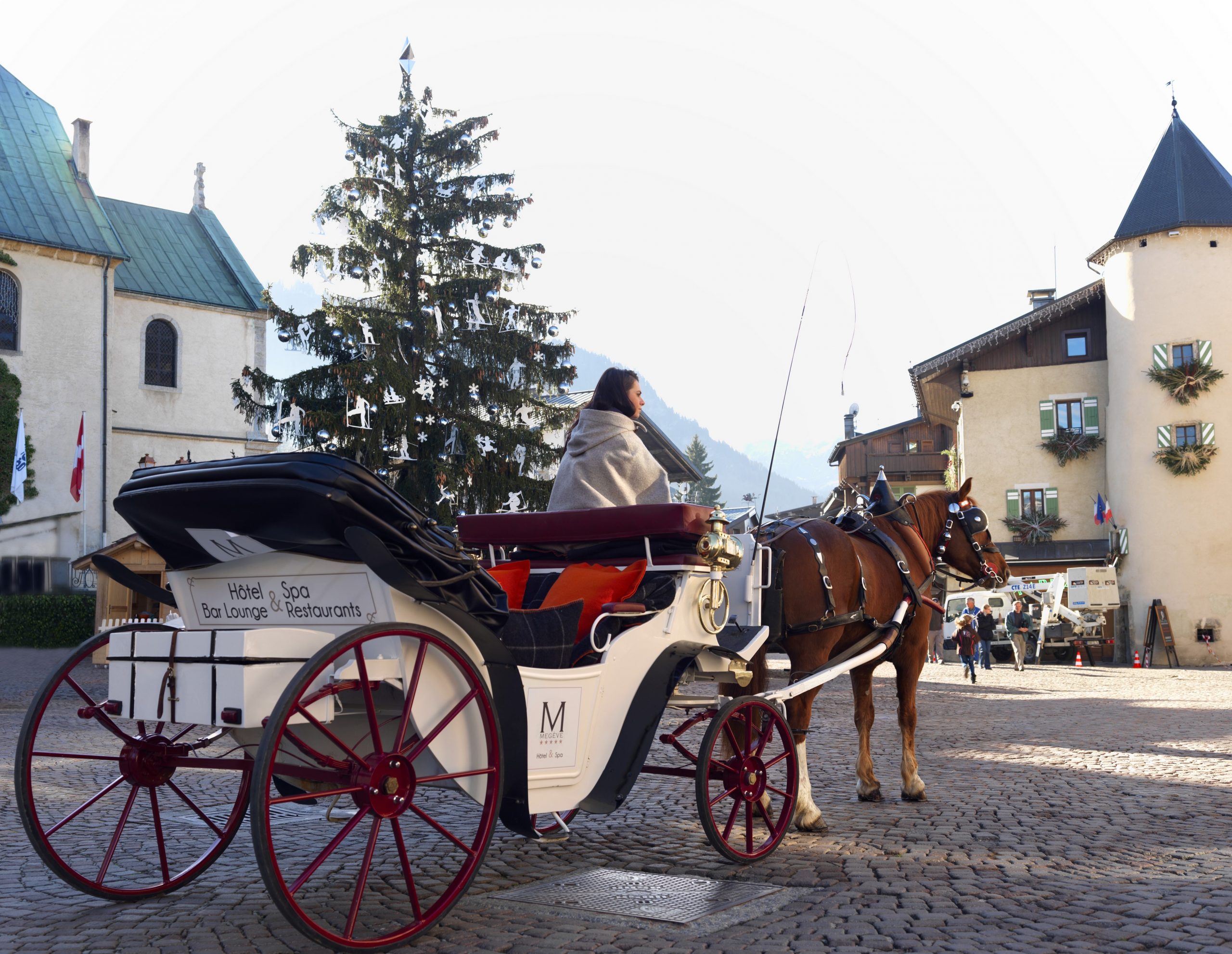 Girl sitting in horse carriage in the French town, Megeve.