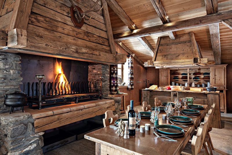 Wooden dining room with fireplace and wine at romantic French ski resort, Les Fermes de Marie.